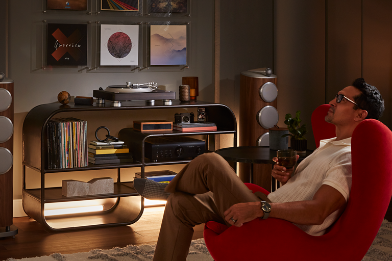 A man sitting and listening to a turntable