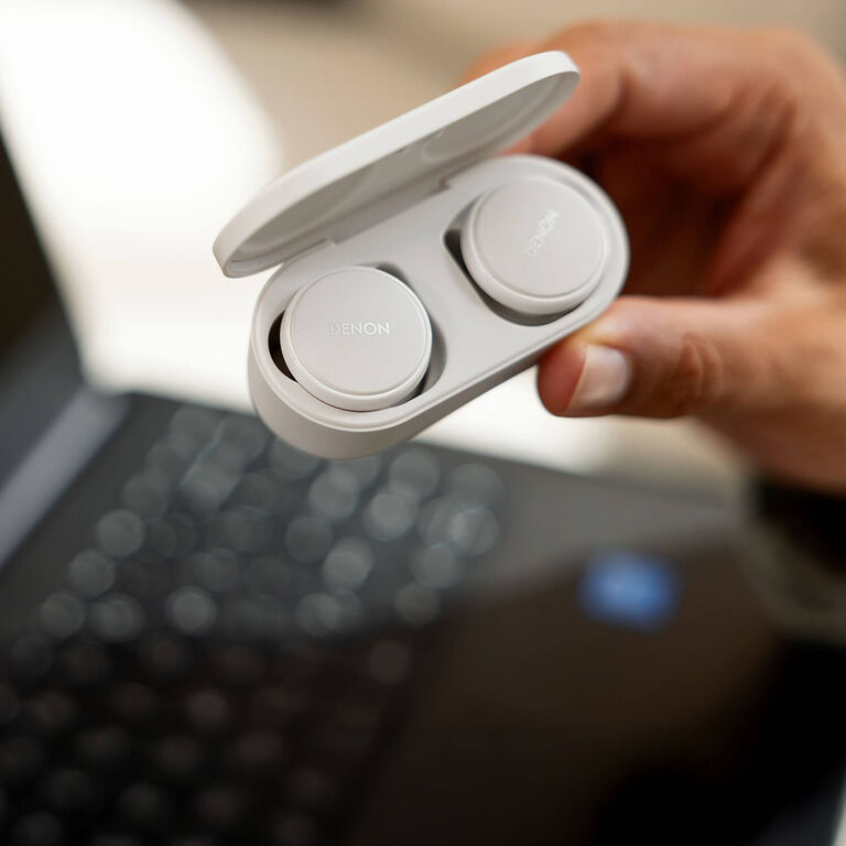 A woman holding Denon PerLs
