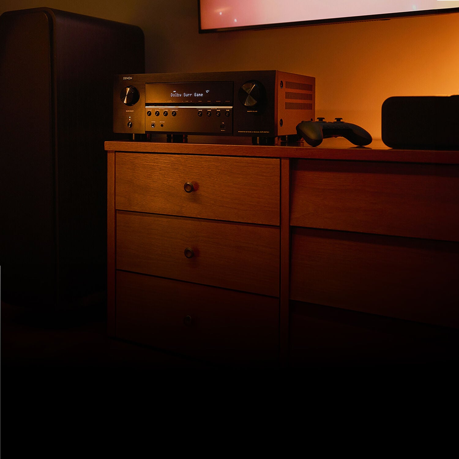 An avr in a dark room with a game console controller next to it.