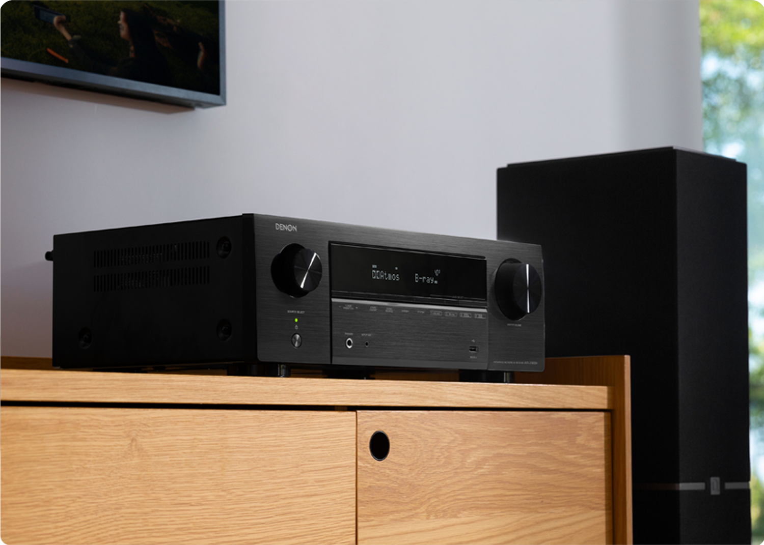 AVR-X1800H next to a tower speaker under a tv