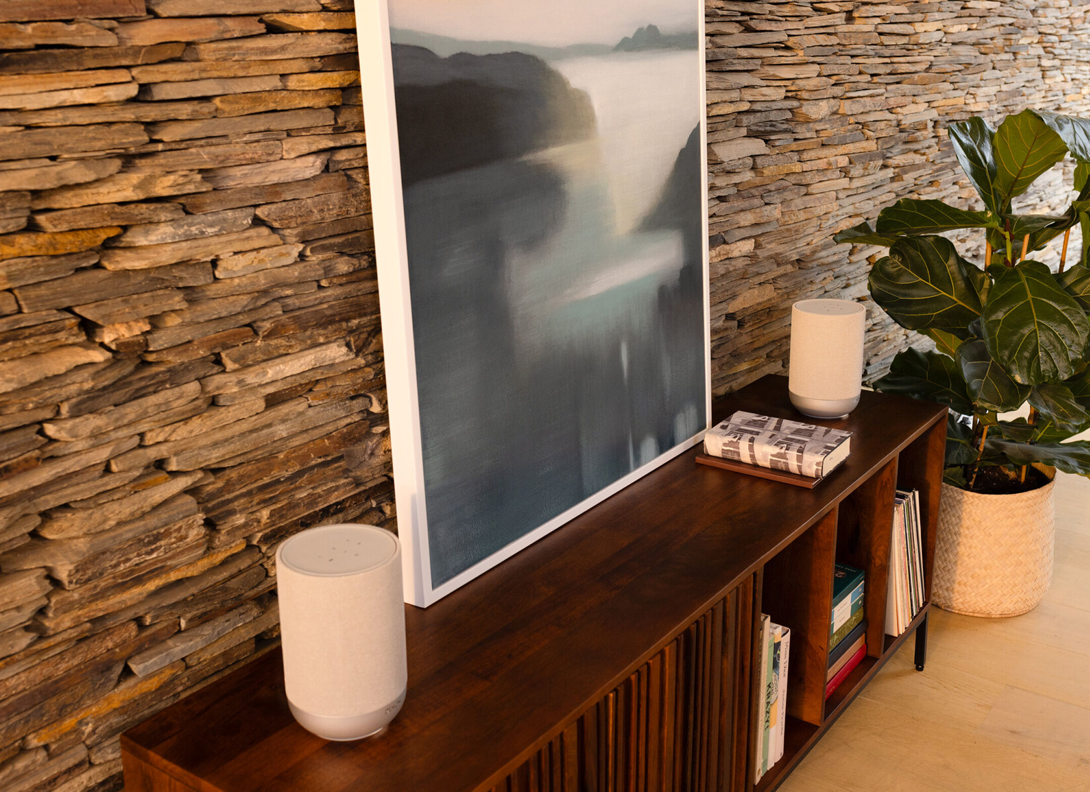 Two Denon Home speakers placed on either side of a television