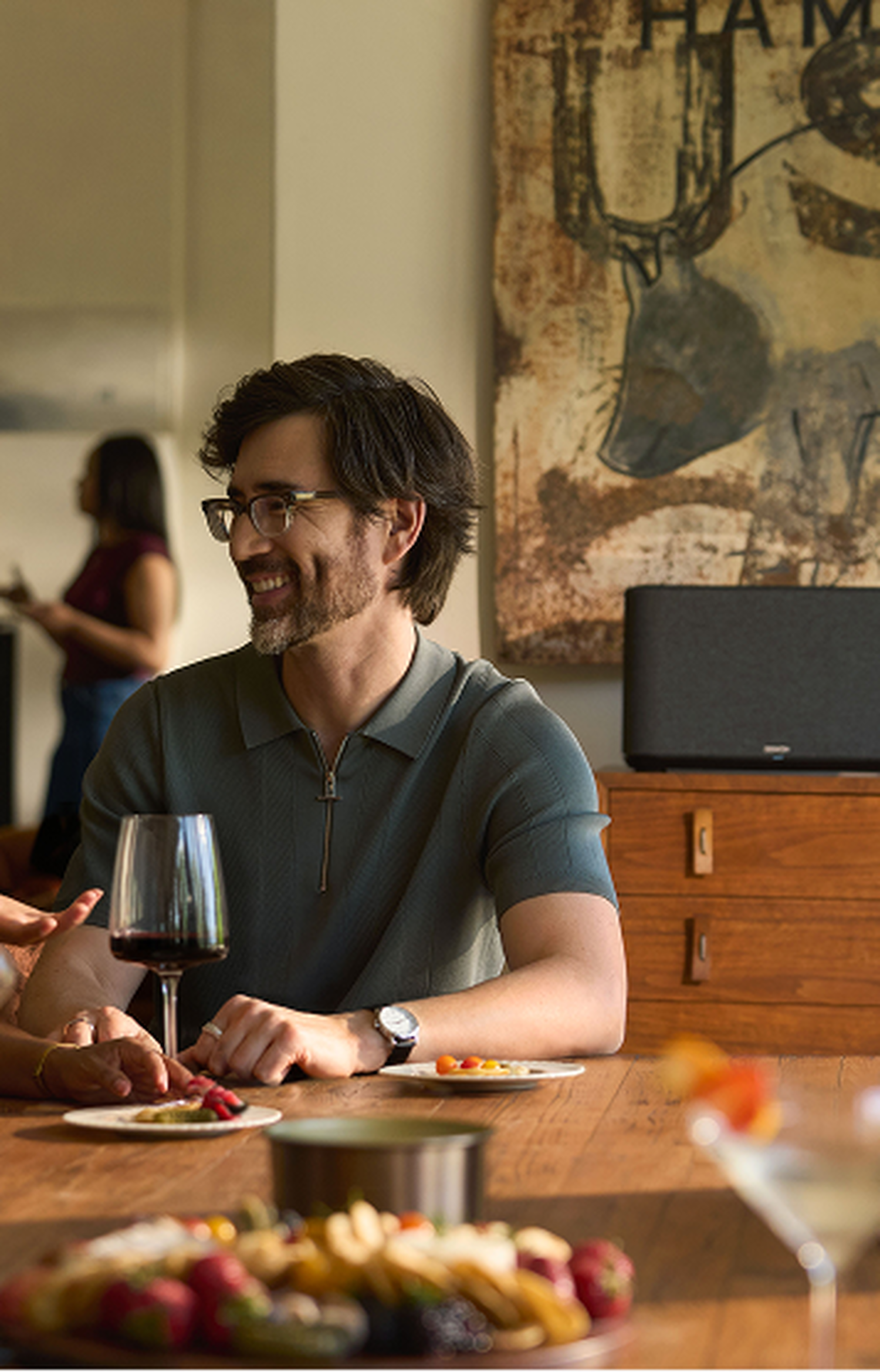 Man sitting at table listening to Denon Home 350
