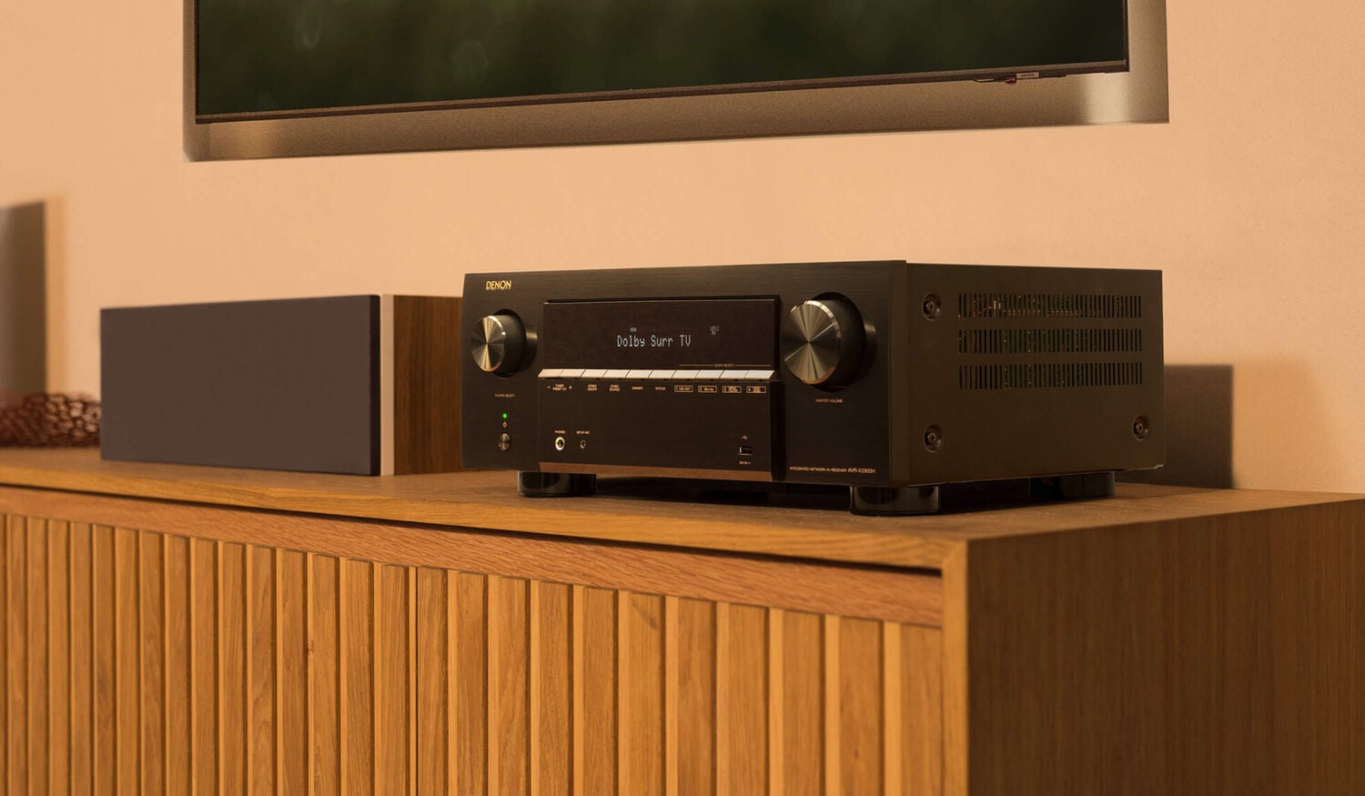 A person using the HEOS app to control a Denon Home Speaker