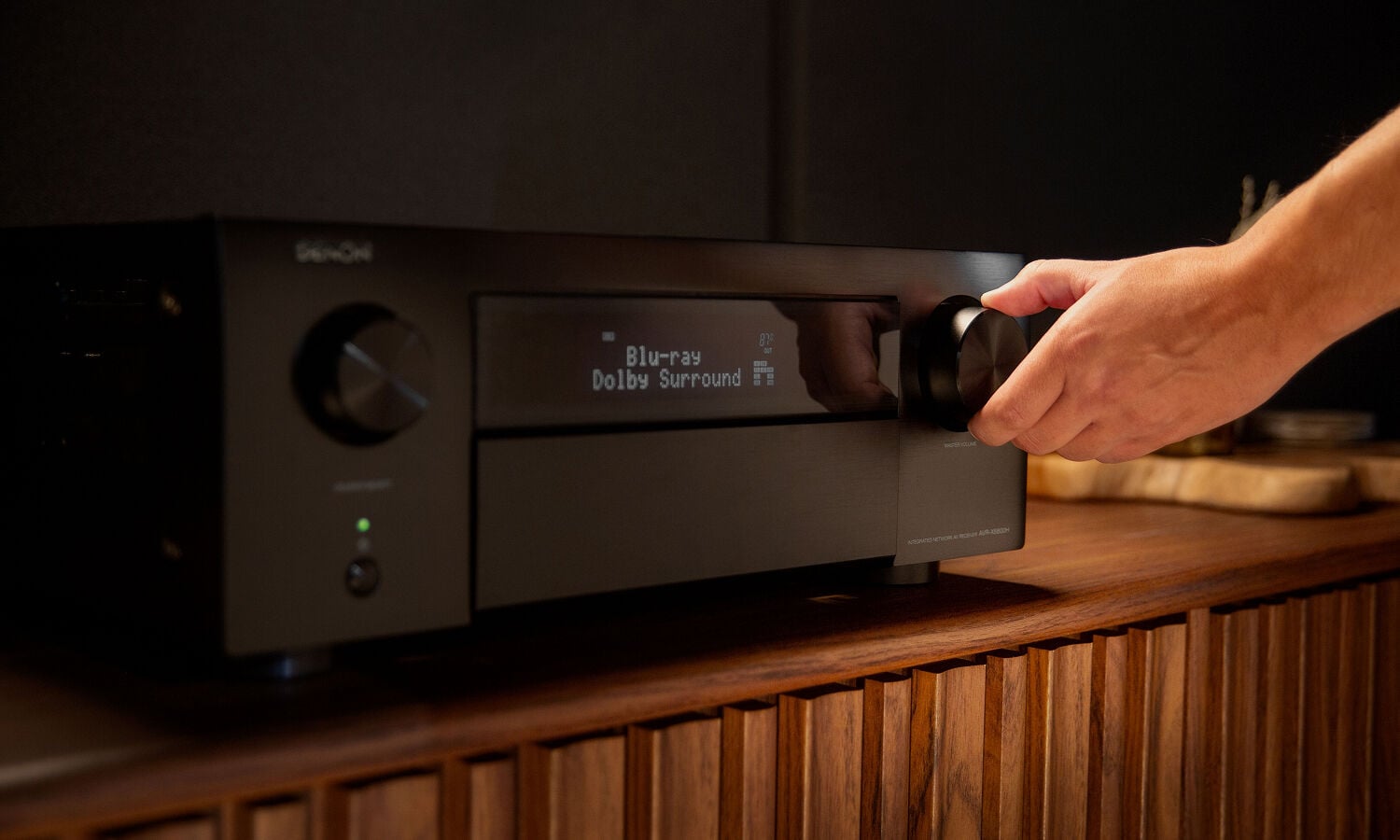 a man turning up the volume on an AVR