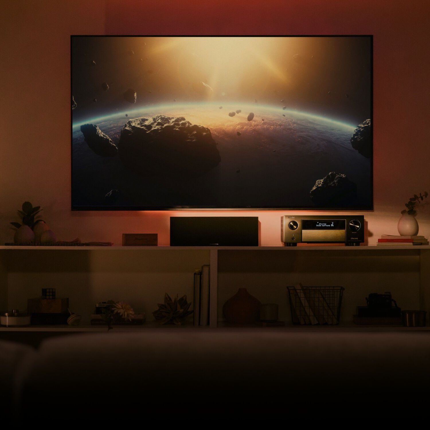 An avr in a home theater, sitting between floor speakers