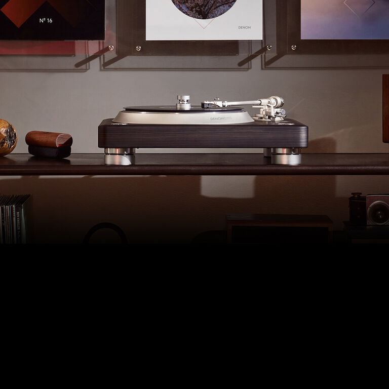 A turntable with a wall of albums above it.