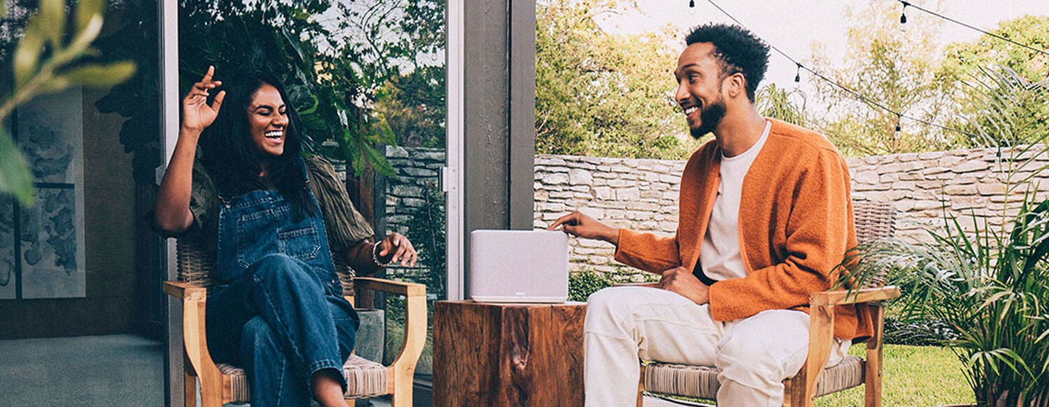 A couple listening to a speaker outdoors