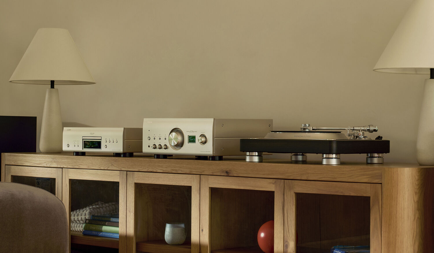 A CD-Player, Amplifier, and Vinyl Player next to eachother on an entertainment center