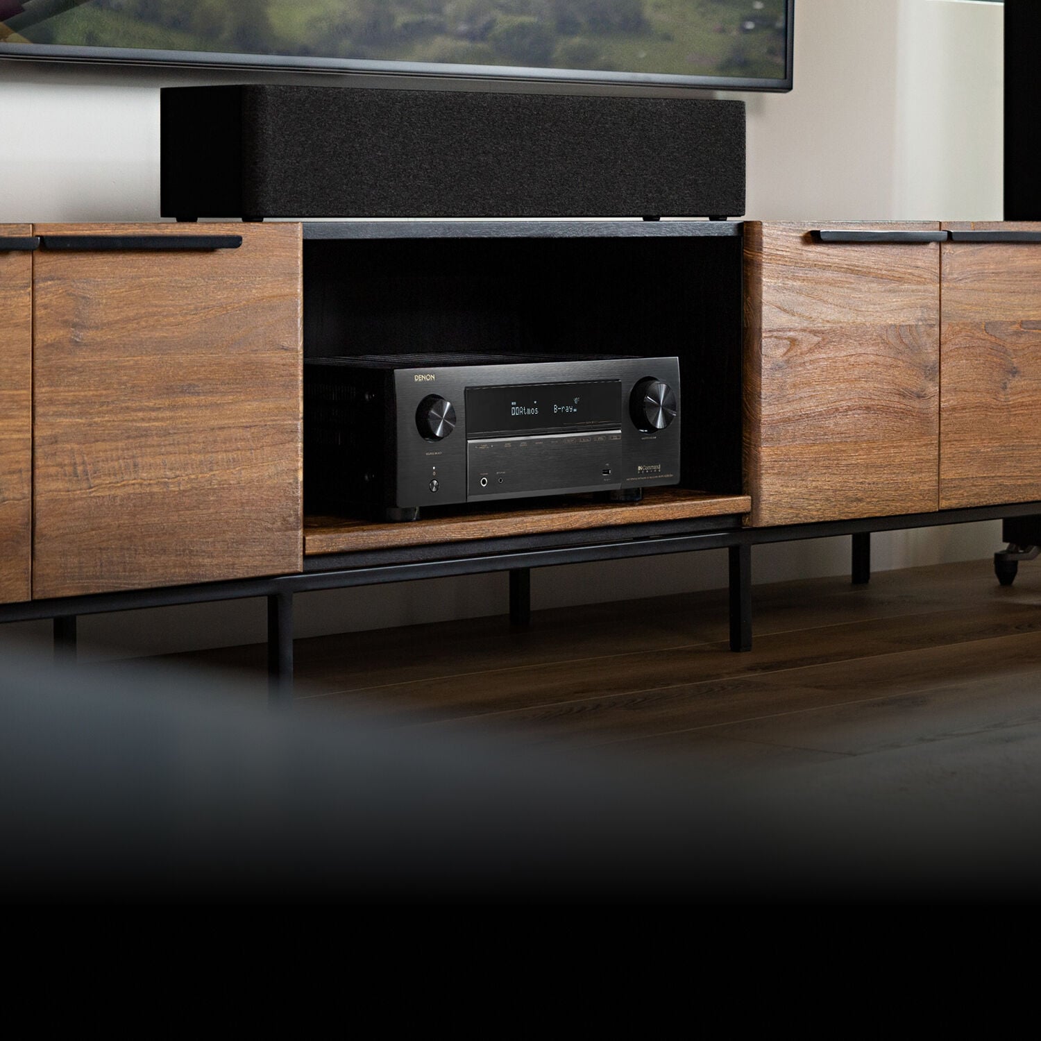 AVR-X2800H sitting in an entertainment center surrounded by LCR speakers