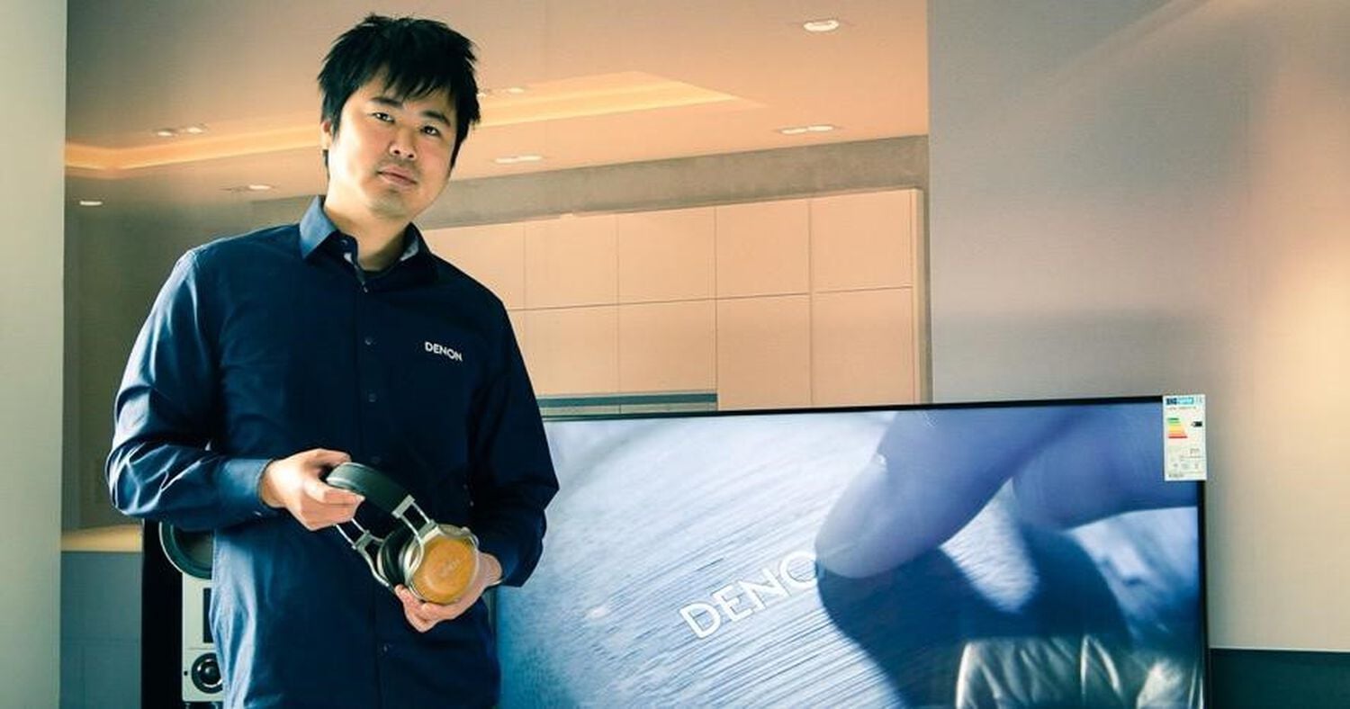 A man holding Denon Headphones