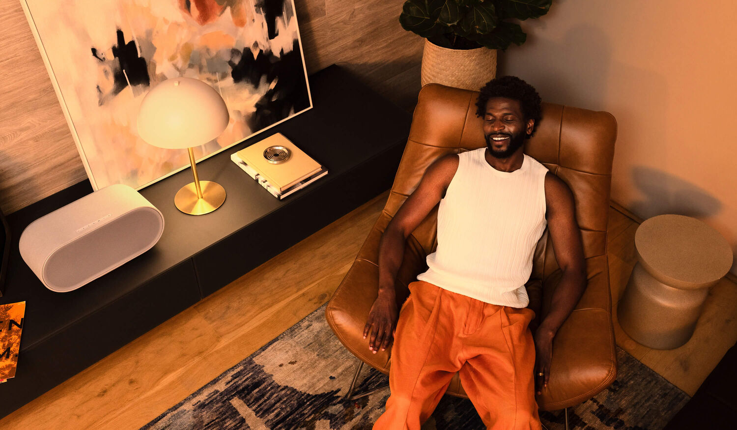 a man laying back in a chair listening on a Denon Home 600
