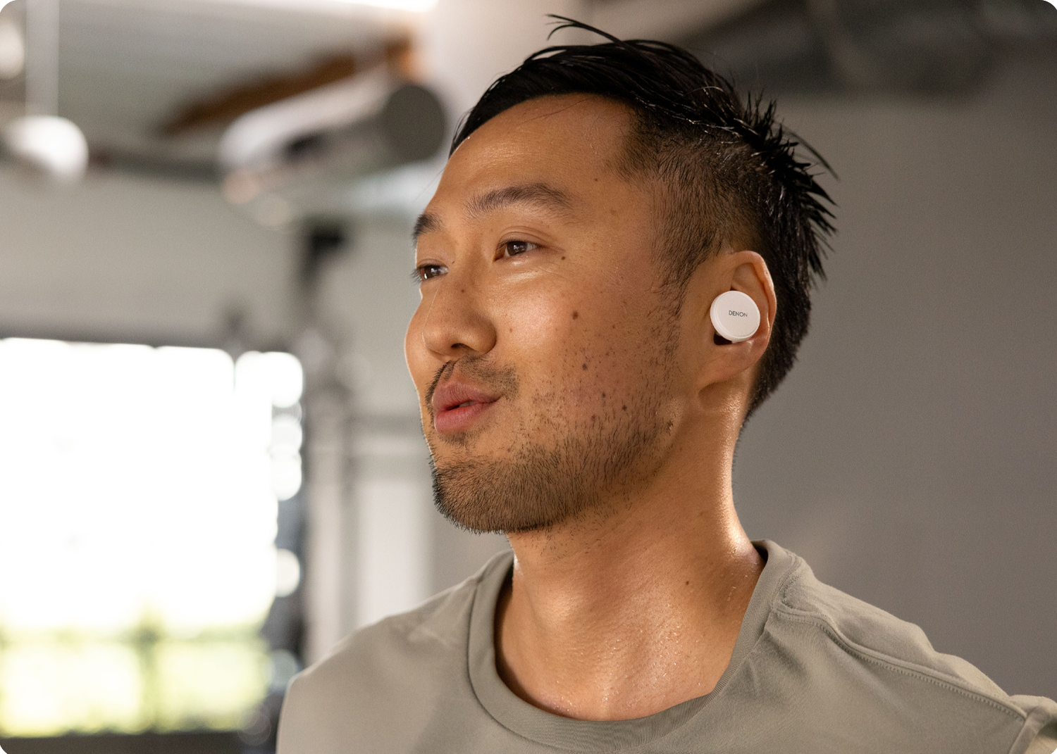 A man working out while wearing Denon PerL Pros