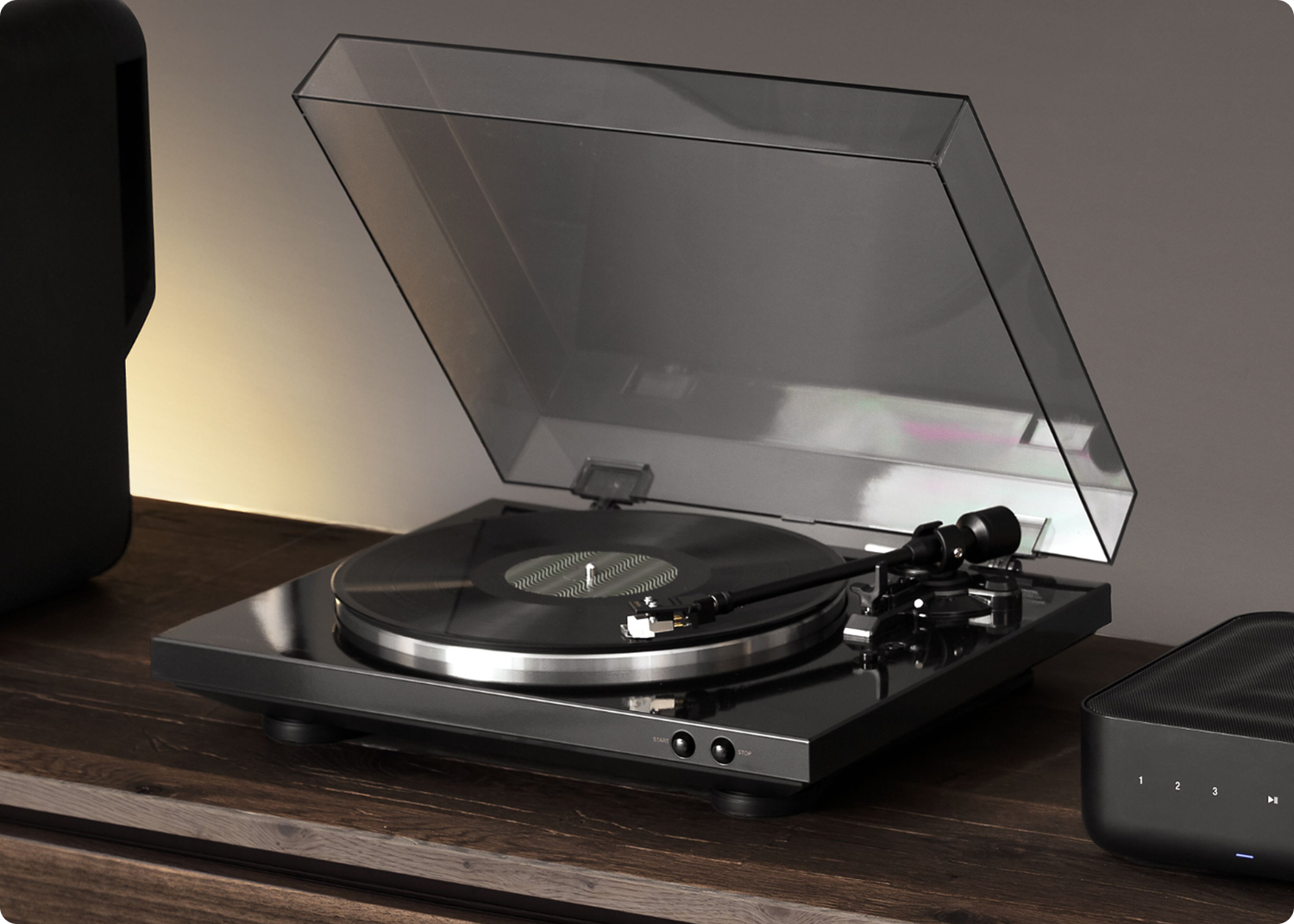 DP-300F sitting on furniture next to a Denon Home Amp
