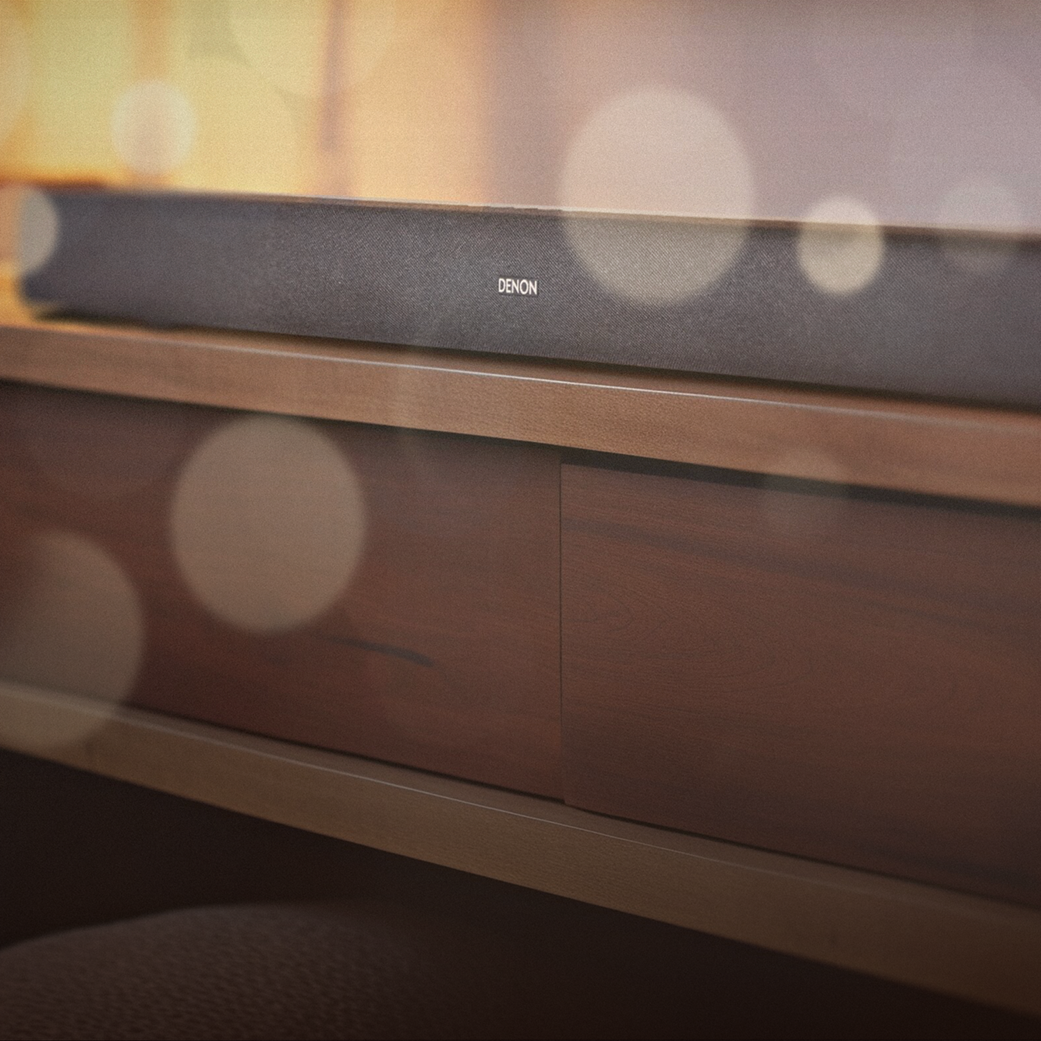 A Denon soundbar below a mounted tv